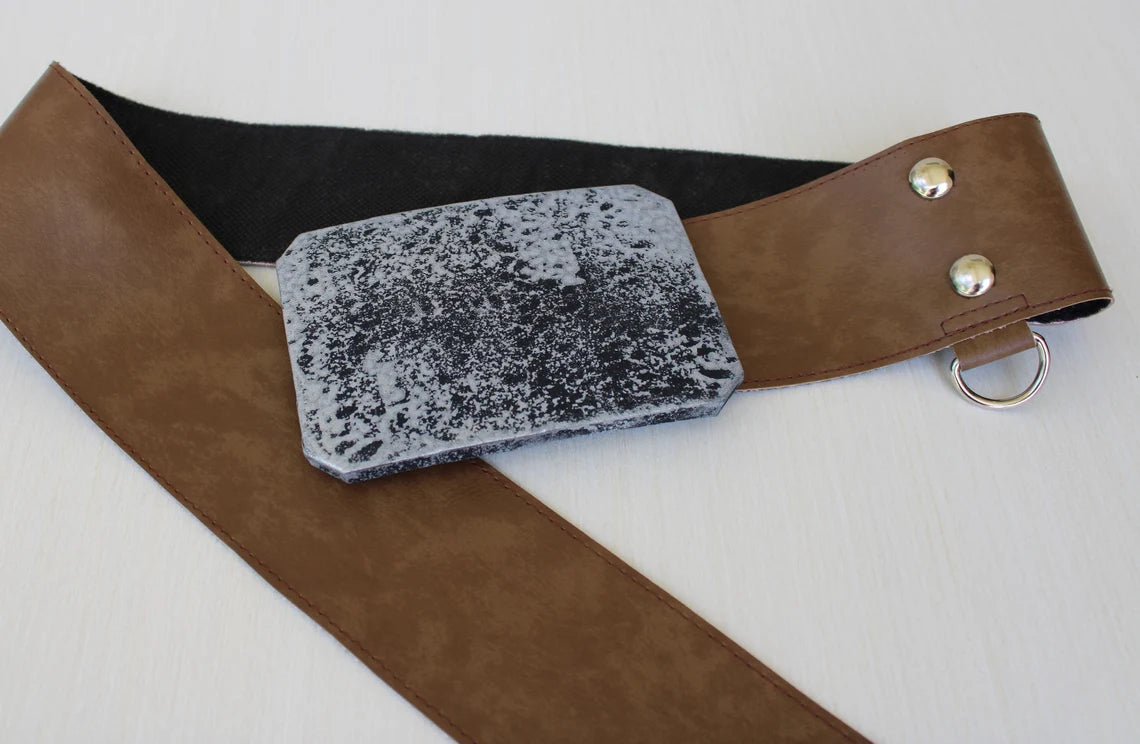 Close-up of Luke Skywalker costume belt buckle — wide brown leather belt with distressed silver rectangular buckle, two silver snaps and a D-ring attached