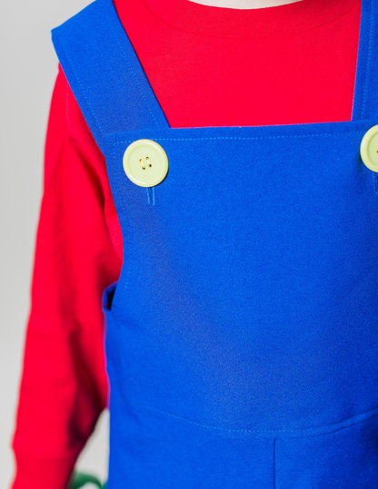 Close-up detail of handmade Mario Bros costume — blue polyester overalls with plastic yellow buttons over a red long sleeve t-shirt