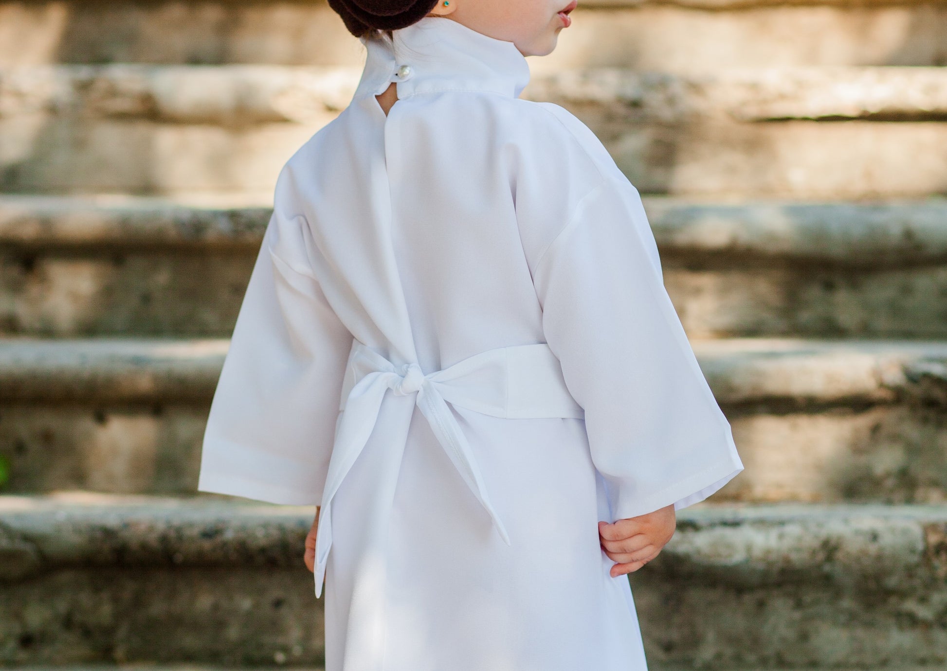 Close-up back detail of handmade Princess Leia kids costume — white robe with tied belt and button closure at neckline
