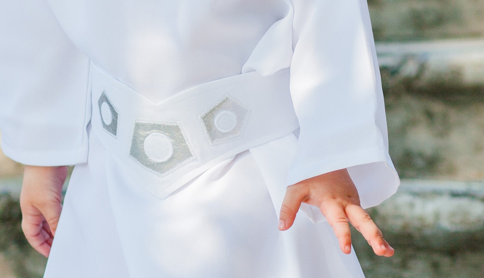 Front close-up of handmade Princess Leia kids costume belt — white fabric belt with silver hexagonal and circular embroidery