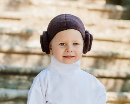 Close-up of toddler wearing handmade Princess Leia brown bun headpiece with white turtleneck costume